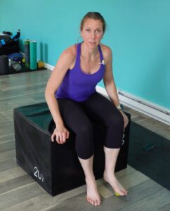 Dr. Chloe sitting with the ball beneath her foot scanning the entire bottom of the foot for sensitive areas